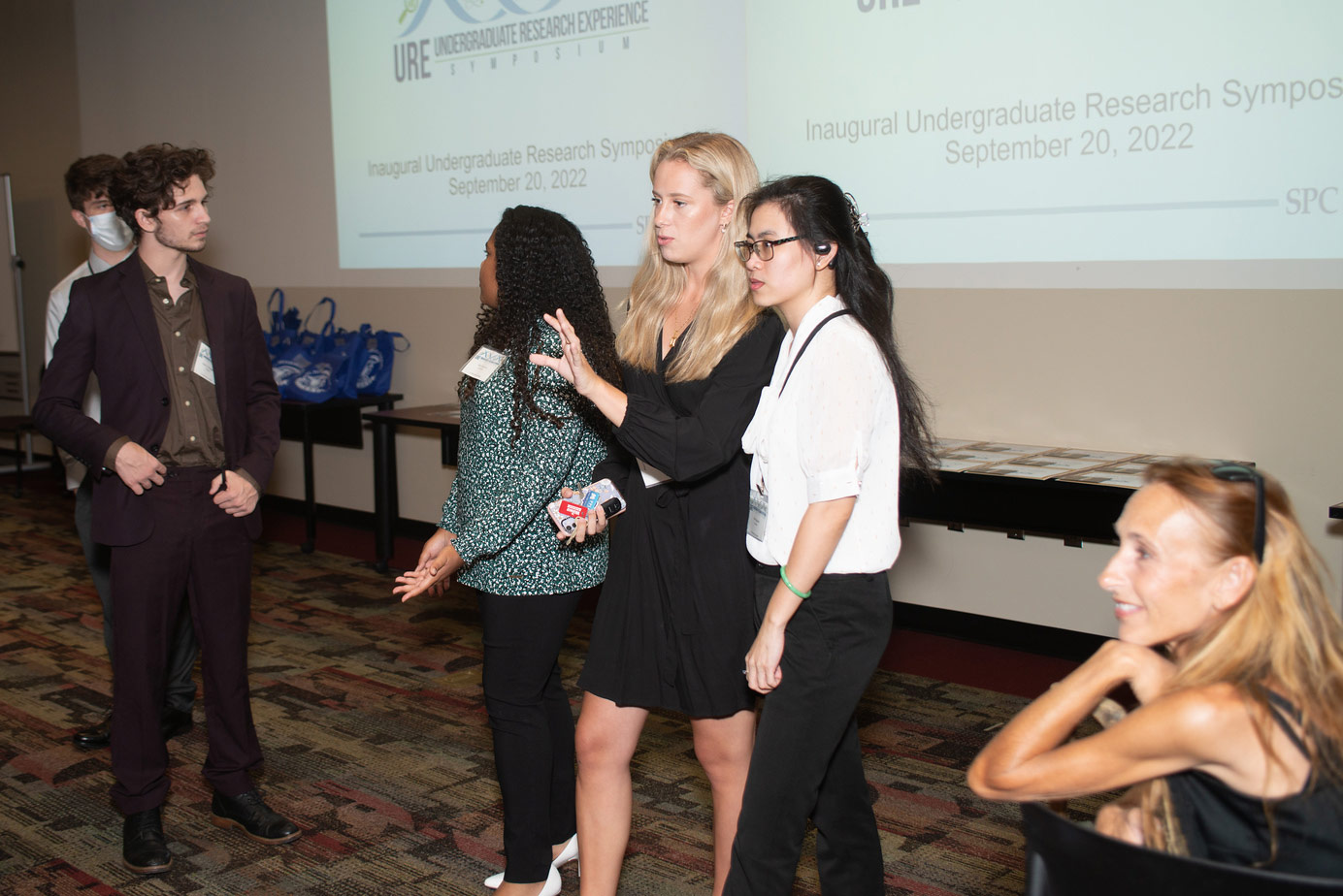 three students and reviewers discussing a presentation