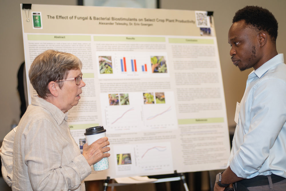 student discussing presentation board with person