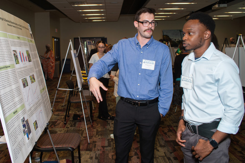 two students reviewing presentation board