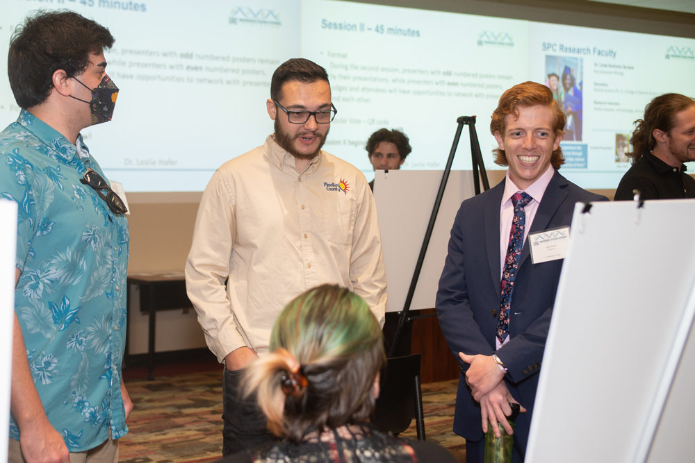 three students and reviewers discussing a presentation