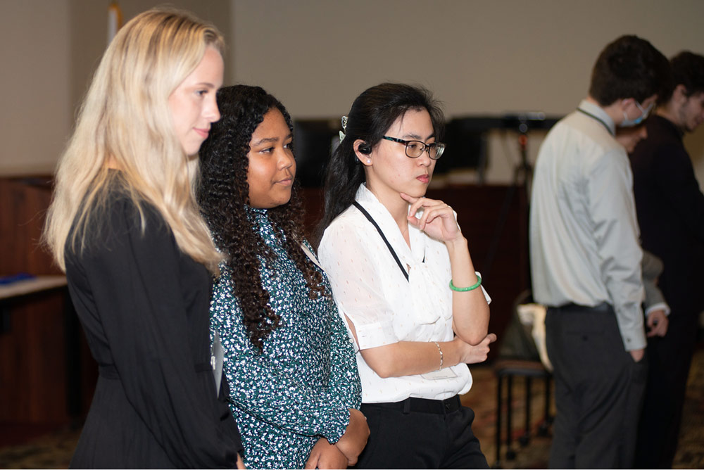 three students and reviewers discussing a presentation